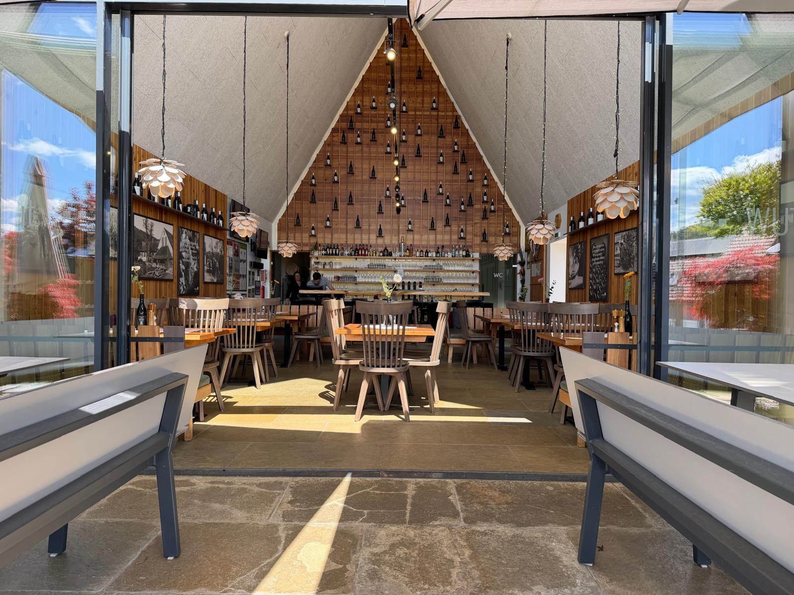 Buschenschank Wutte – Innenraum mit Blick auf Bar, Holzwand und Sitzbereich